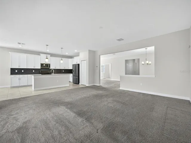a view of a kitchen with refrigerator and white cabinets