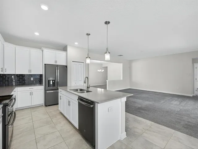 a kitchen with a sink a counter top space appliances and cabinets