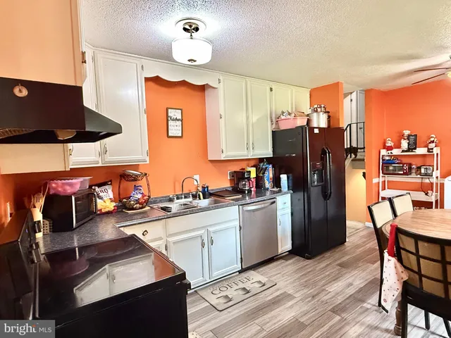 a kitchen that has a lot of cabinets a sink and appliances in it