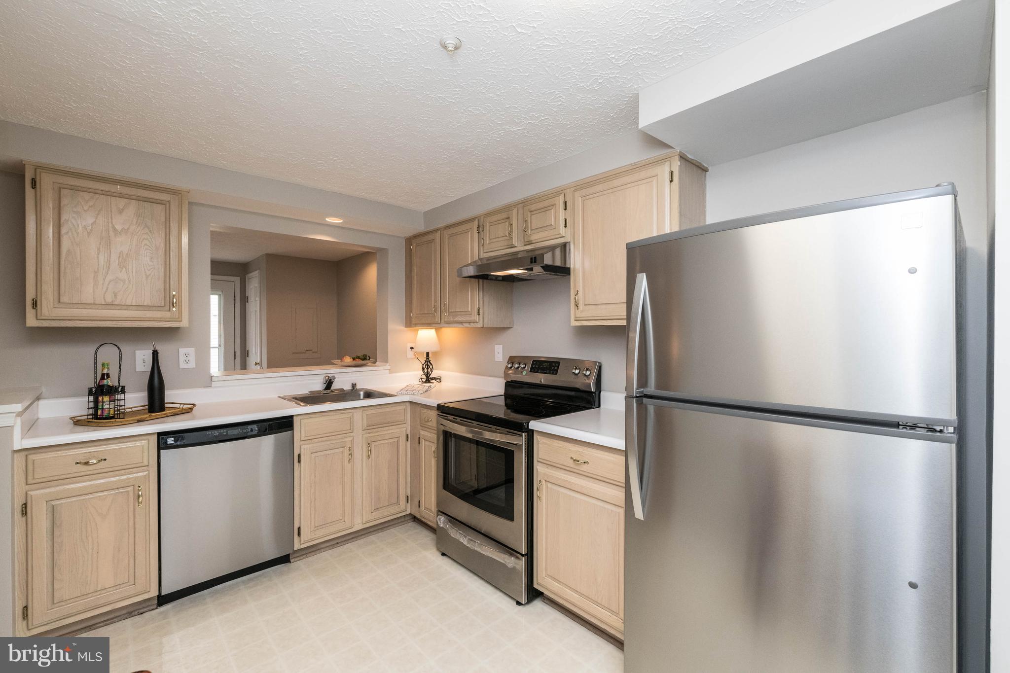 4132 Maple Path Circle, Unit 61 Baltimore, MD 21236 - Photo 19 of 47 a kitchen with white cabinets and white stainless steel appliances