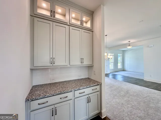 a kitchen with granite countertop a sink and white cabinets