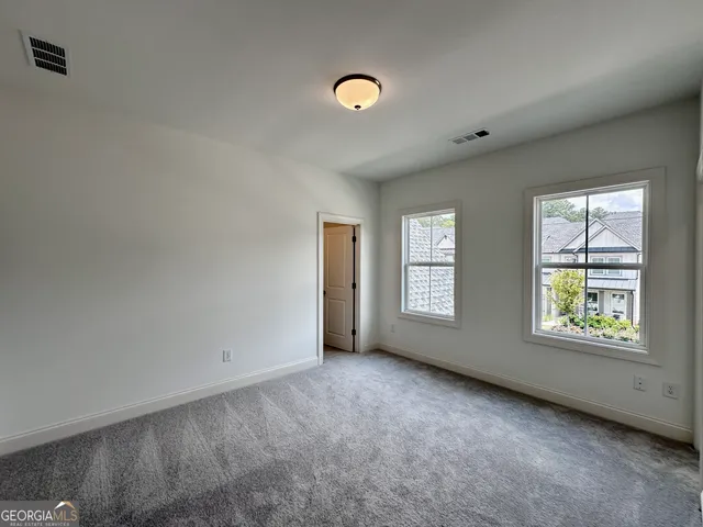 an empty room with windows and closet
