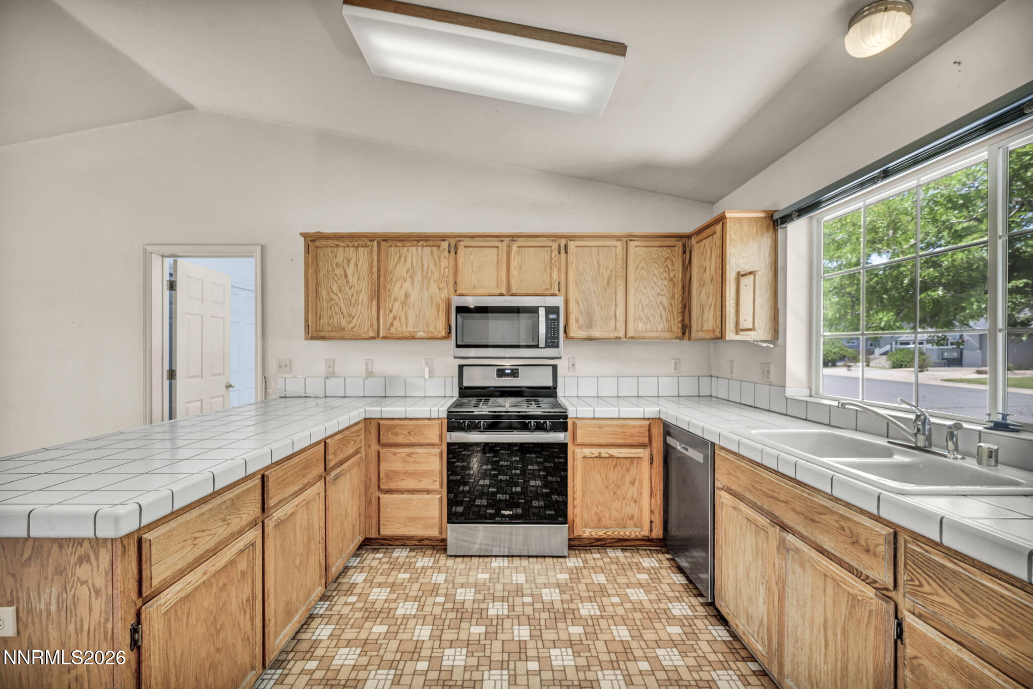 692 Lassen Way Gardnerville, NV 89460 - Photo 11 of 34 a kitchen with stainless steel appliances granite countertop a stove sink and cabinets