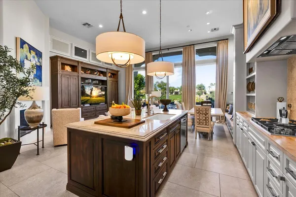 a kitchen with a stove a kitchen island wooden cabinets and stainless steel appliances