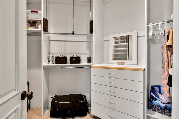 a bedroom with a large bed a flat tv screen and a chandelier