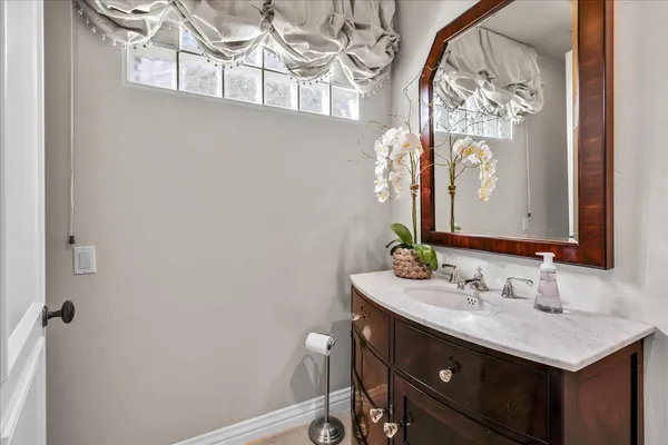 a bathroom with a granite countertop sink and a mirror