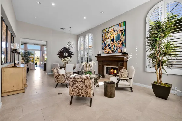 a living room with furniture a chandelier and a fireplace
