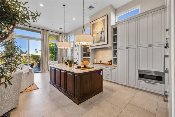 a kitchen with stainless steel appliances a stove a sink dishwasher and a dining table with garden view