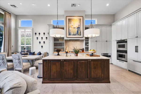 a large kitchen with stainless steel appliances granite countertop a sink a stove and a wooden floors