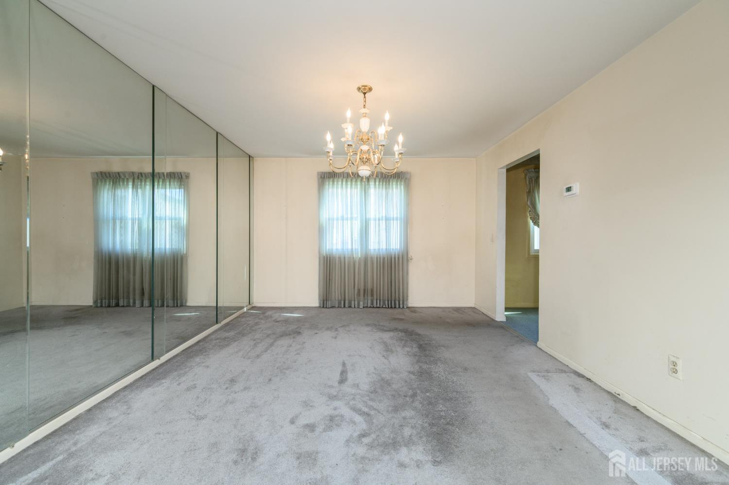 112 Apple Tree Lane Union, NJ 07083 - Photo 7 of 46 an empty room with chandelier fan and windows