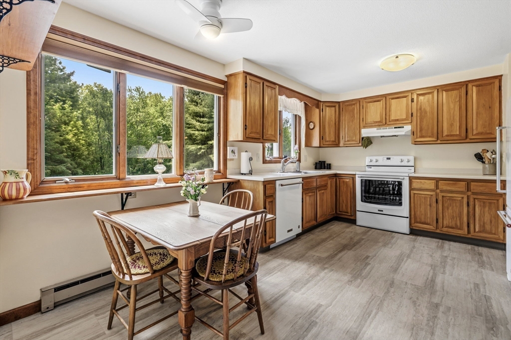 788 Burts Pit Road Northampton, MA 01062 - Photo 12 of 42 a kitchen with a stove a sink a dining table and chairs