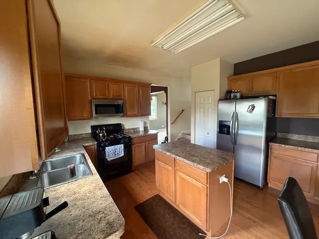 a kitchen with granite countertop a refrigerator stove and oven