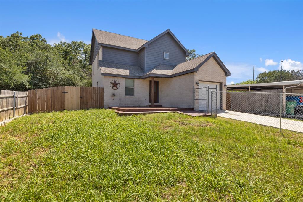 1713 Bronco Road Granbury, TX 76049 - Photo 6 of 23 Front exterior featuring a brick and siding facade, attached garage, covered carport, chain link and wood fencing, and a front wood deck