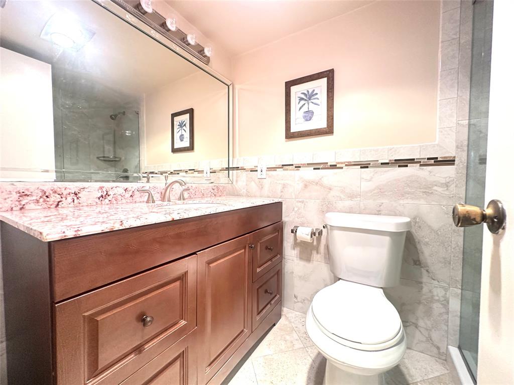 2009 Berkshire A, Unit 2009 Deerfield Beach, FL 33442 - Photo 16 of 57 a bathroom with a toilet sink and mirror