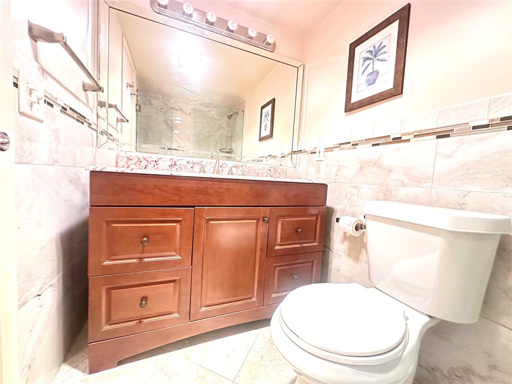 2009 Berkshire A, Unit 2009 Deerfield Beach, FL 33442 - Photo 17 of 57 a bathroom with a toilet a sink and mirror