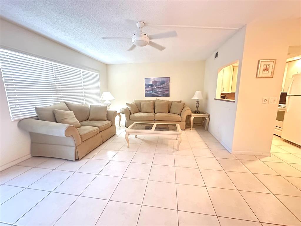 2009 Berkshire A, Unit 2009 Deerfield Beach, FL 33442 - Photo 2 of 57 a living room with furniture and a rug