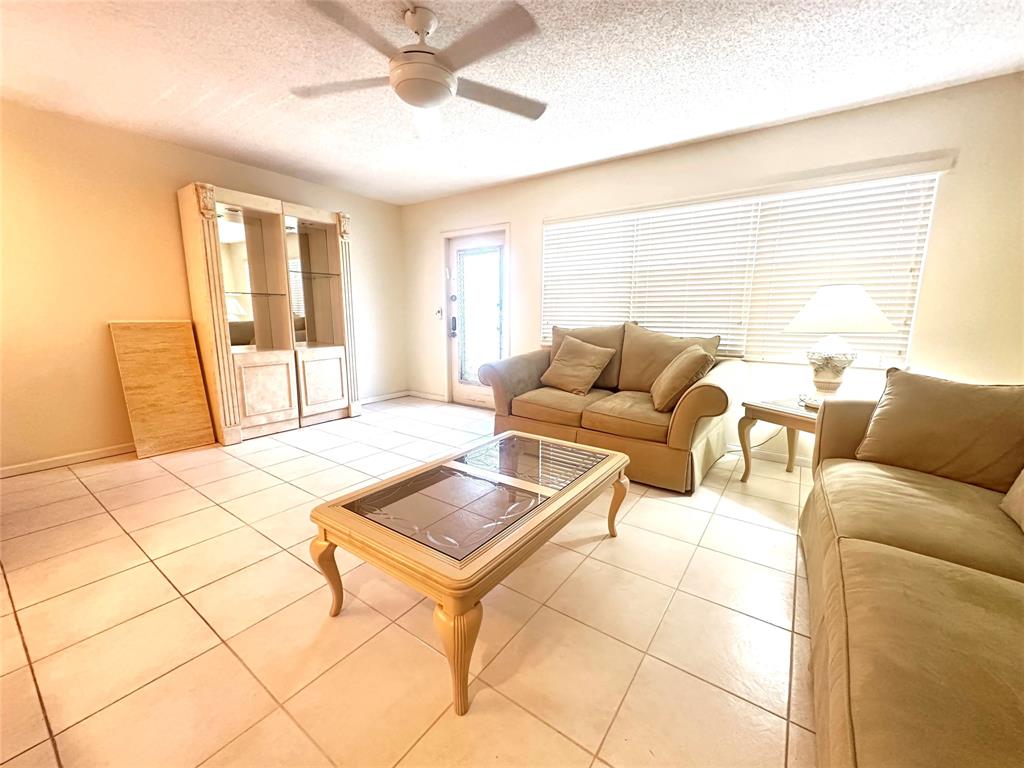 2009 Berkshire A, Unit 2009 Deerfield Beach, FL 33442 - Photo 4 of 57 a living room with furniture and a large window