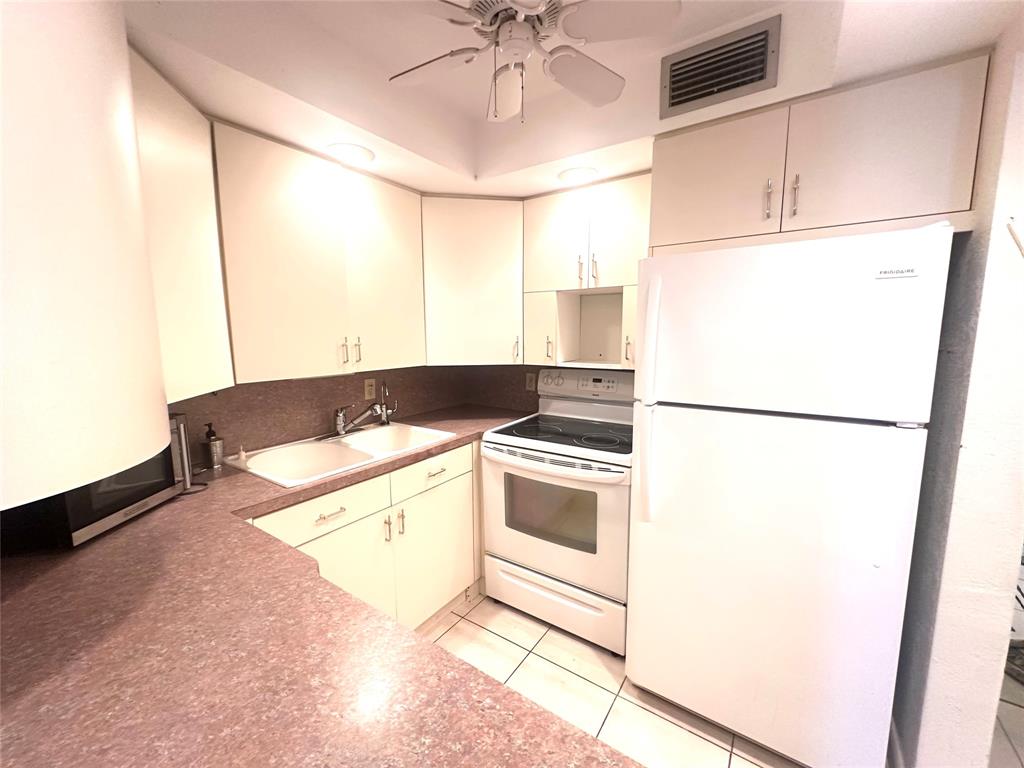 2009 Berkshire A, Unit 2009 Deerfield Beach, FL 33442 - Photo 8 of 57 a kitchen with a refrigerator and a stove