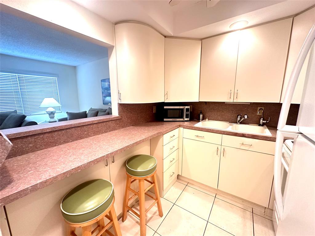 2009 Berkshire A, Unit 2009 Deerfield Beach, FL 33442 - Photo 10 of 57 a bathroom with a granite countertop sink and a mirror