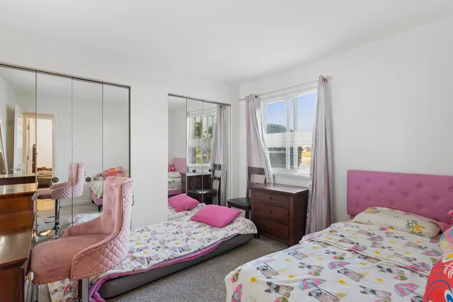 a bedroom with two beds and large windows