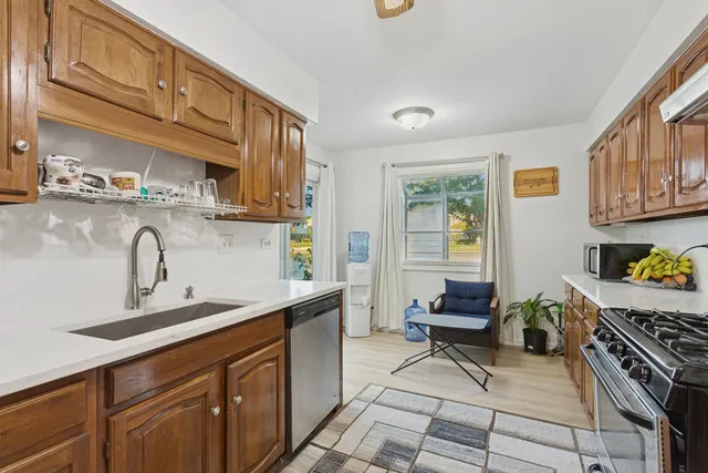 a kitchen with stainless steel appliances a sink a stove and cabinets