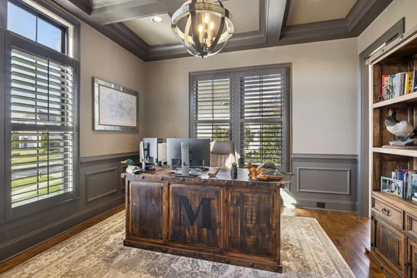 a kitchen with a dining table chairs cabinets and wooden floor