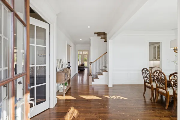 a kitchen with kitchen island a dining table chairs stainless steel appliances and wooden floor
