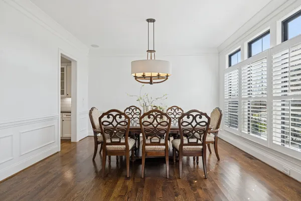 a dining room with furniture a chandelier and wooden floor