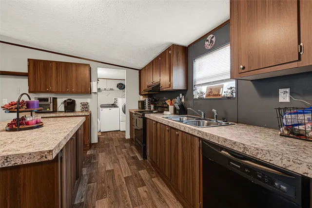 a kitchen with granite countertop a sink a stove and cabinets