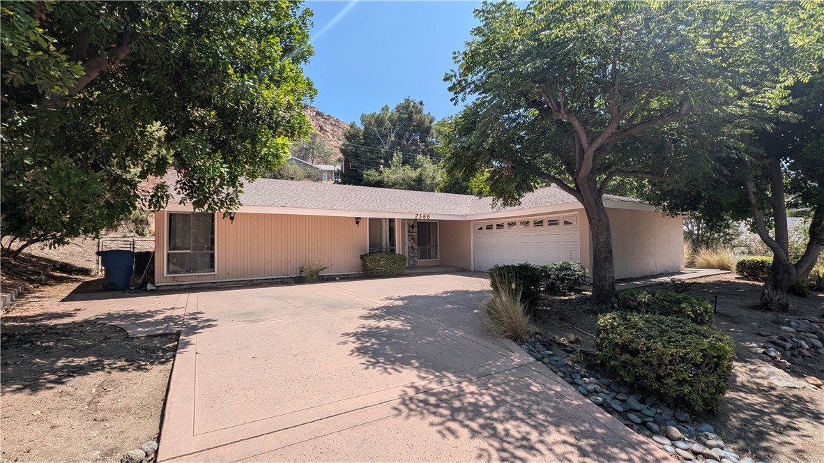 a view of a house with backyard and trees
