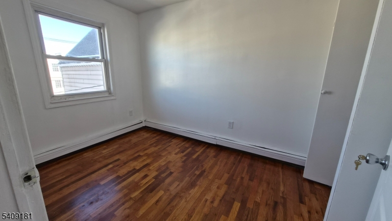 536 Livingston Street Elizabeth Port, NJ 07206 - Photo 14 of 14 an empty room with wooden floor and windows