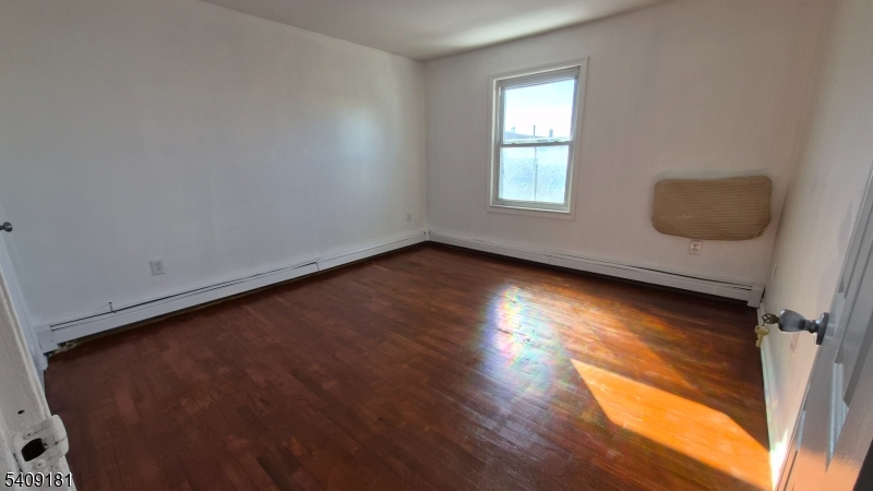 536 Livingston Street Elizabeth Port, NJ 07206 - Photo 6 of 14 an empty room with wooden floor and windows