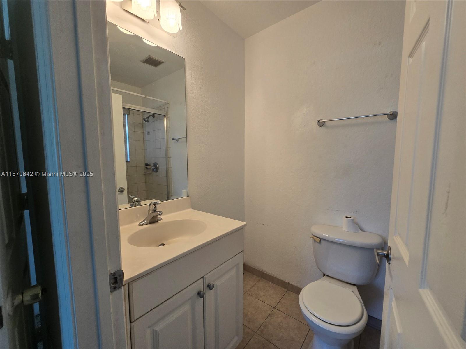 3632 Oleander Terrace, Unit 3632 Riviera Beach, FL 33404 - Photo 12 of 26 a bathroom with a toilet sink and mirror