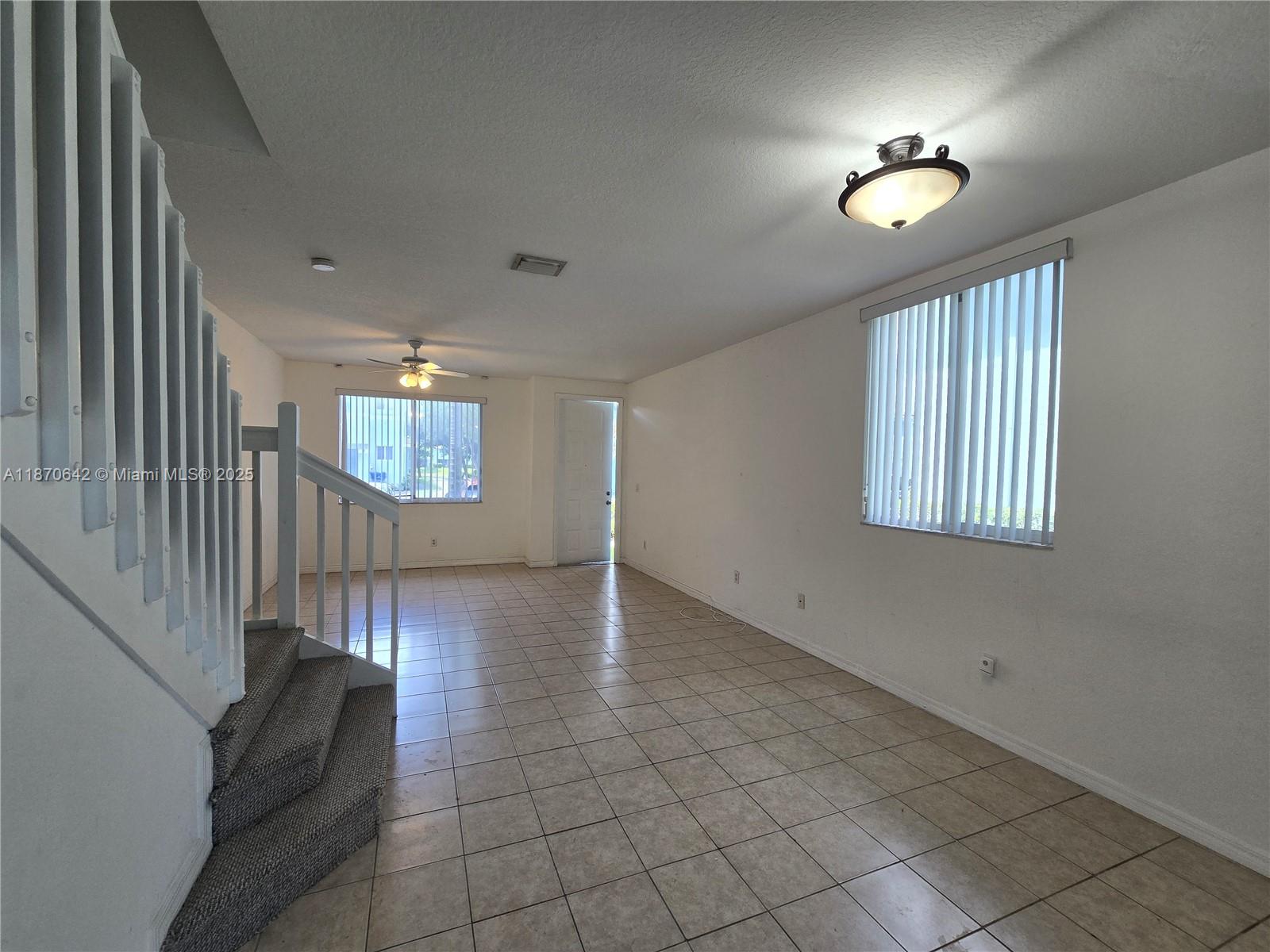 3632 Oleander Terrace, Unit 3632 Riviera Beach, FL 33404 - Photo 3 of 26 an empty room with windows and chandelier fan