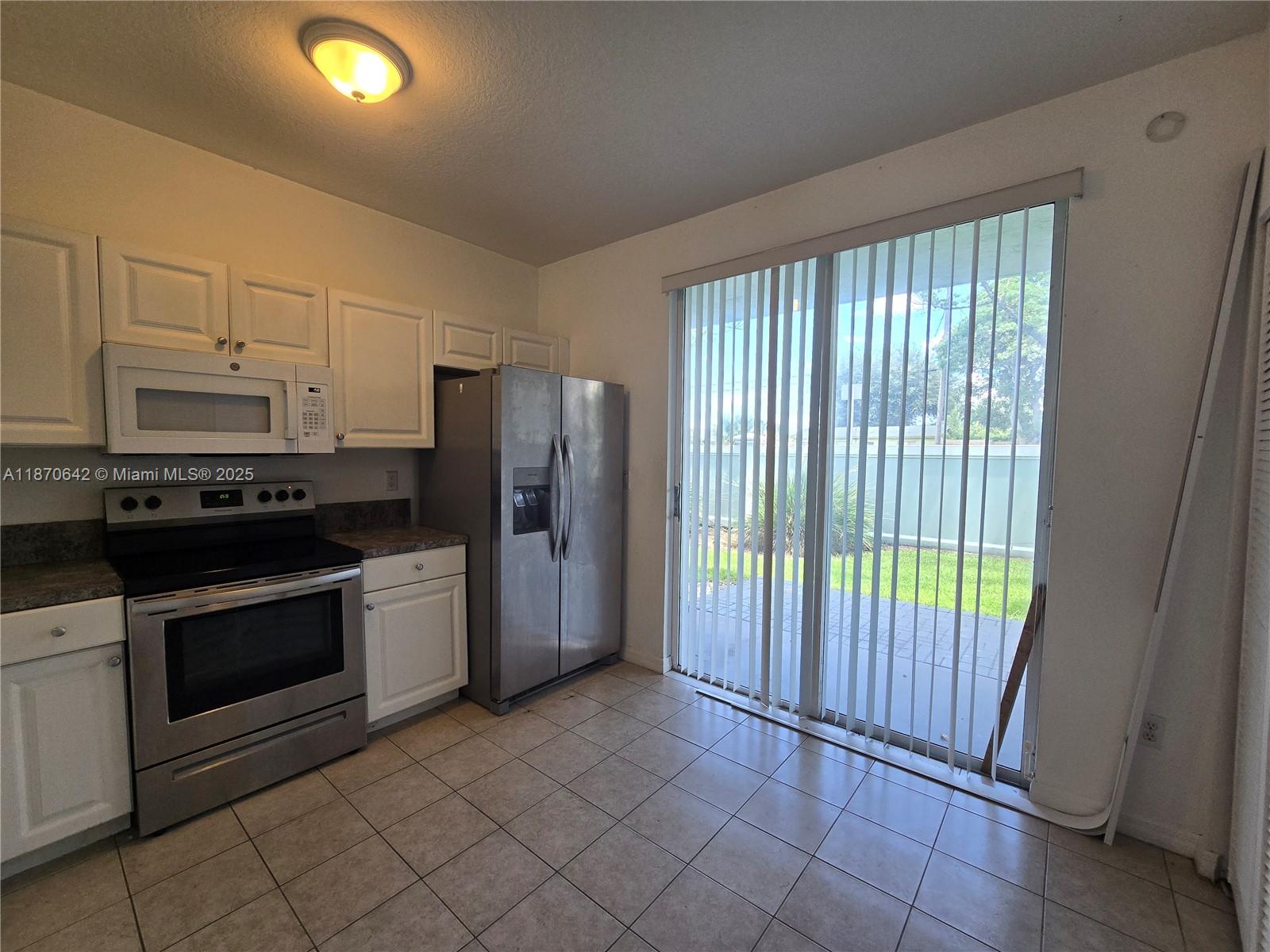 3632 Oleander Terrace, Unit 3632 Riviera Beach, FL 33404 - Photo 4 of 26 a kitchen with a refrigerator and a sink