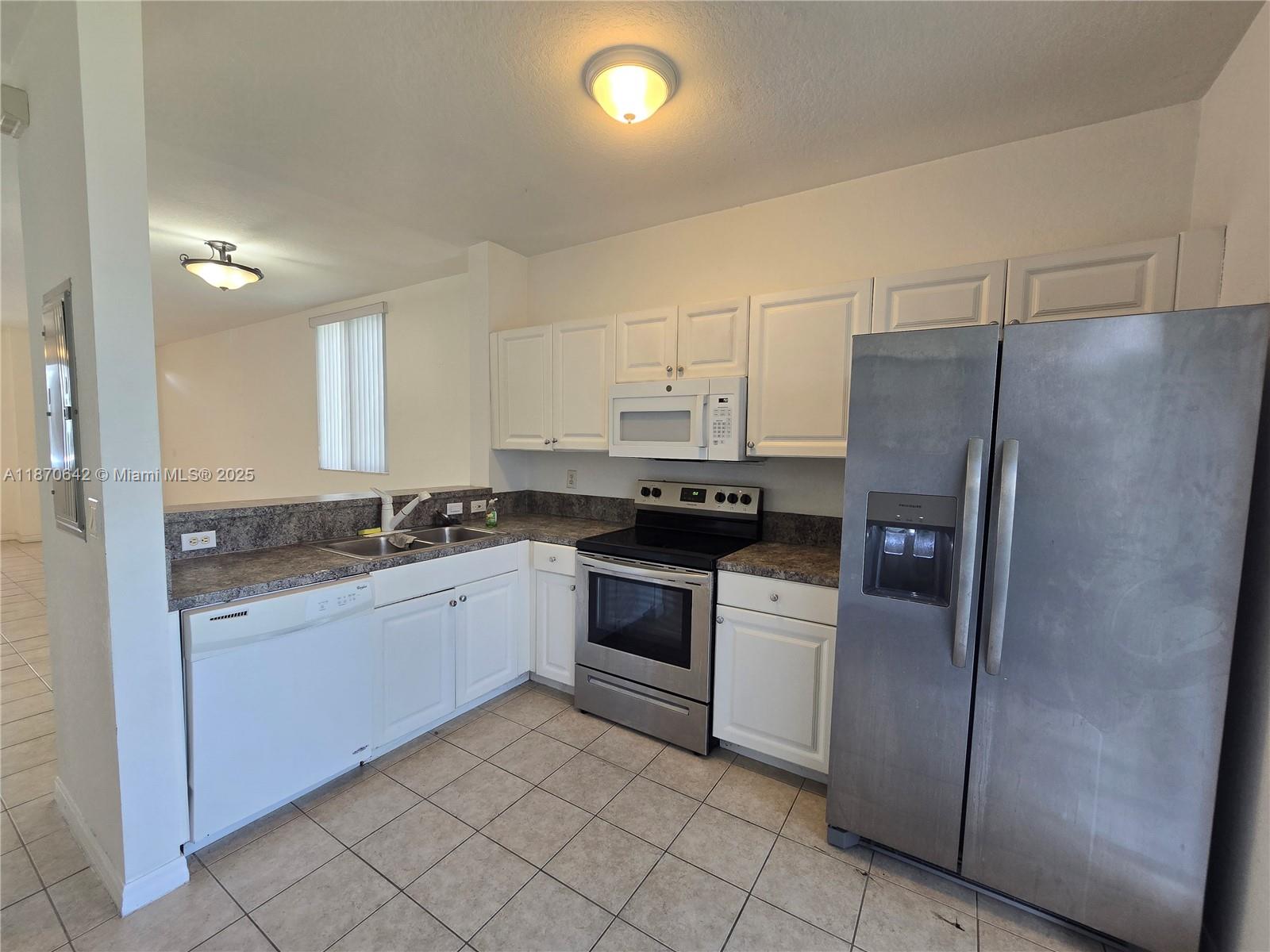 3632 Oleander Terrace, Unit 3632 Riviera Beach, FL 33404 - Photo 6 of 26 a kitchen with a sink cabinets and stainless steel appliances