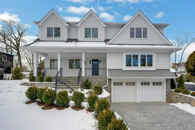 a front view of a house with a yard and potted plants