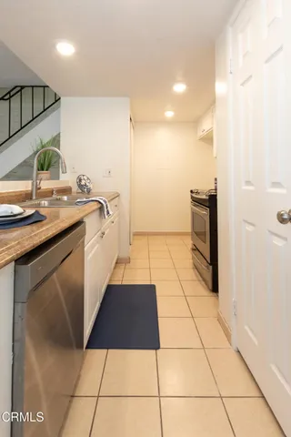 a kitchen with stainless steel appliances granite countertop a sink and a white cabinets