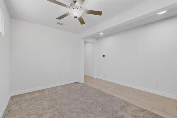 en empty room with ceiling fan and window