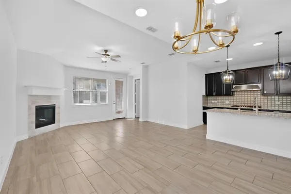a view of a livingroom with a ceiling fan and a kitchen
