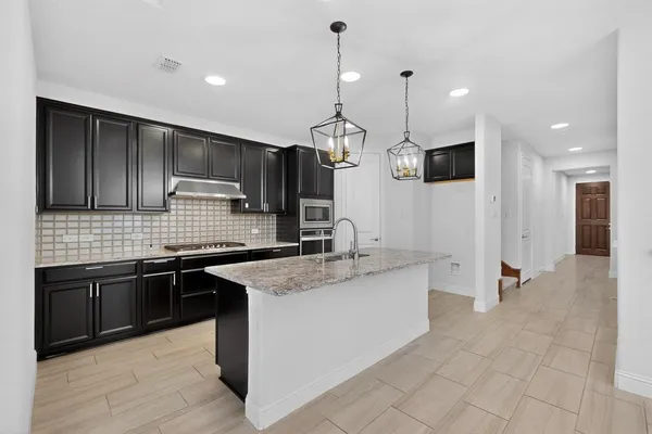 a kitchen with stainless steel appliances granite countertop a sink a stove and a refrigerator