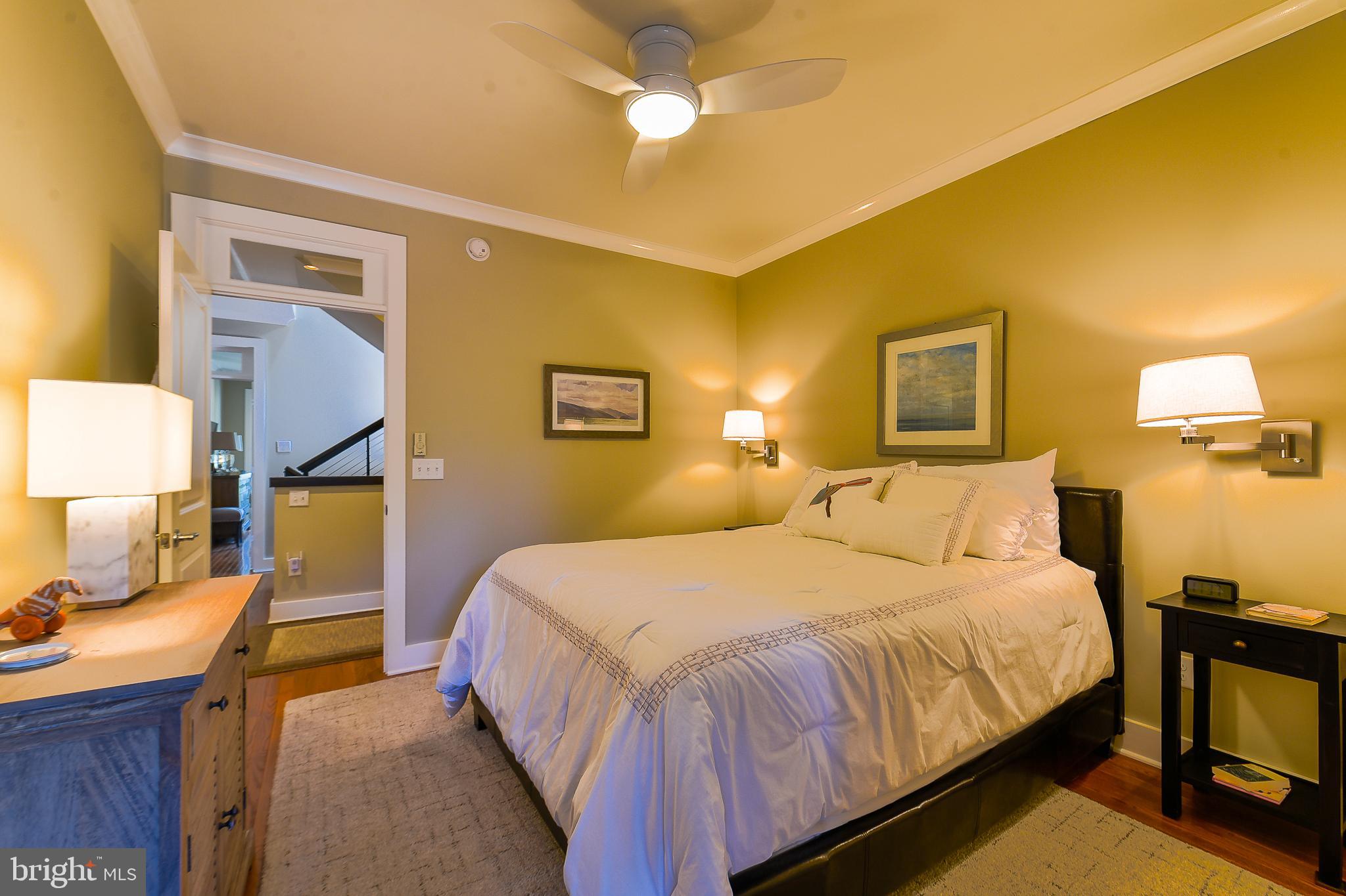 38520 Pine Lane, Unit 2 Rehoboth Beach, DE 19971 - Photo 26 of 71 a bedroom with a bed and a lamp with the wooden floor
