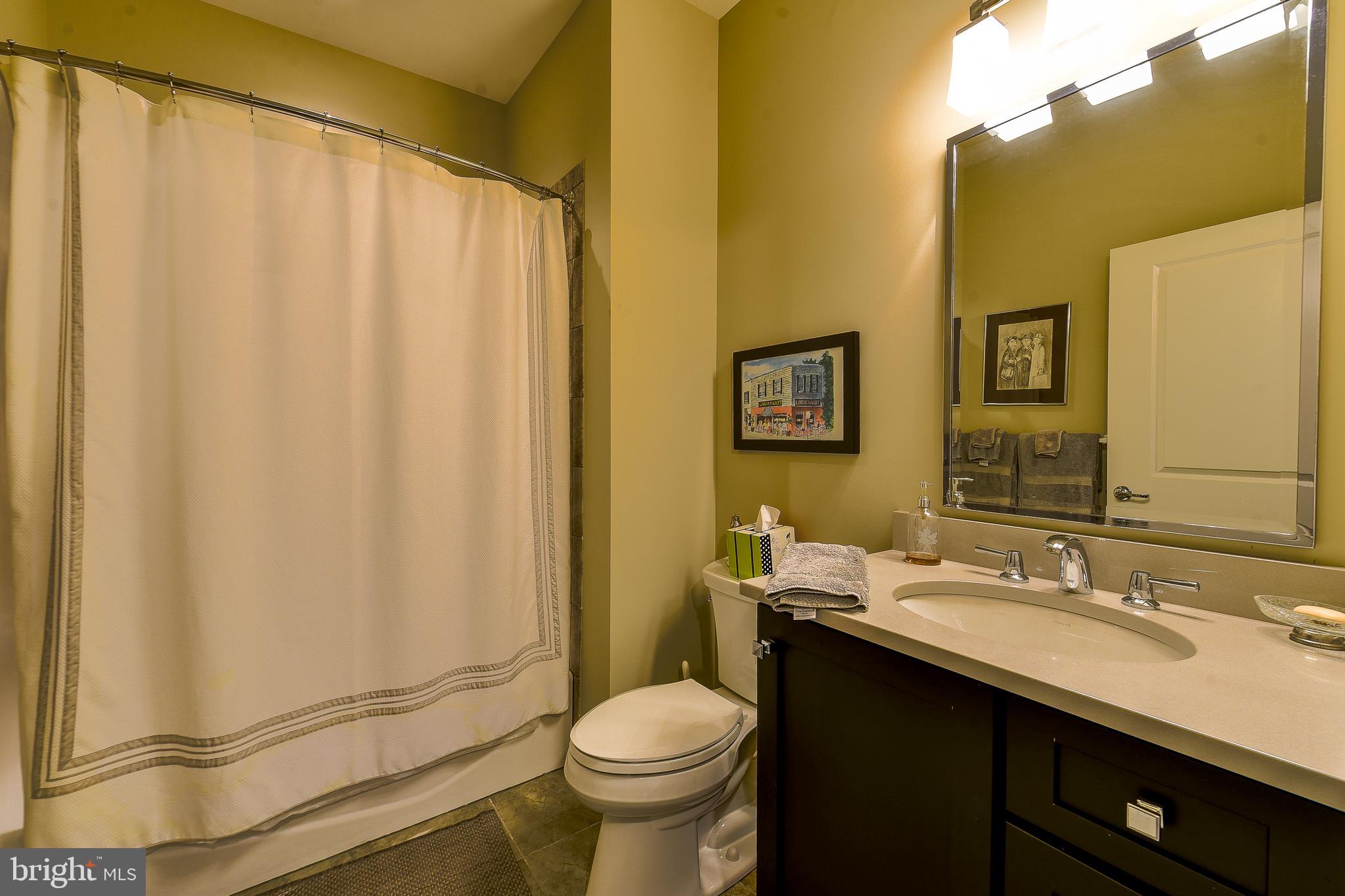 38520 Pine Lane, Unit 2 Rehoboth Beach, DE 19971 - Photo 62 of 71 a bathroom with a granite countertop sink toilet and a mirror