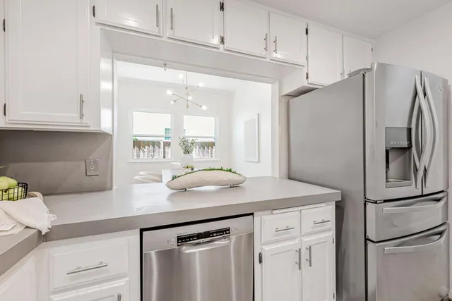 a kitchen with stainless steel appliances a refrigerator sink and cabinets