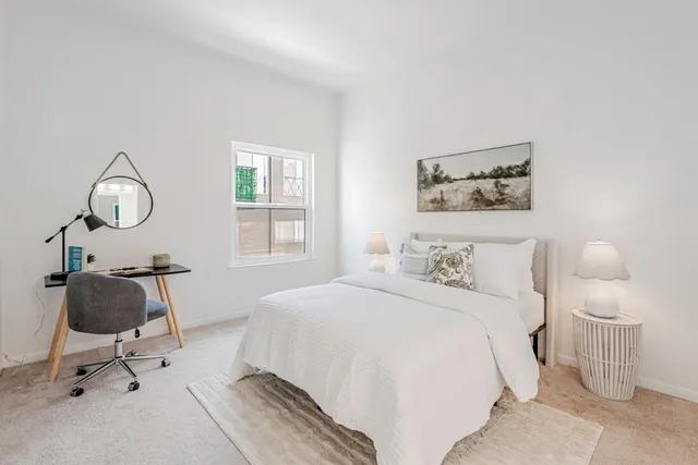 a bedroom with a bed and a painting on the wall