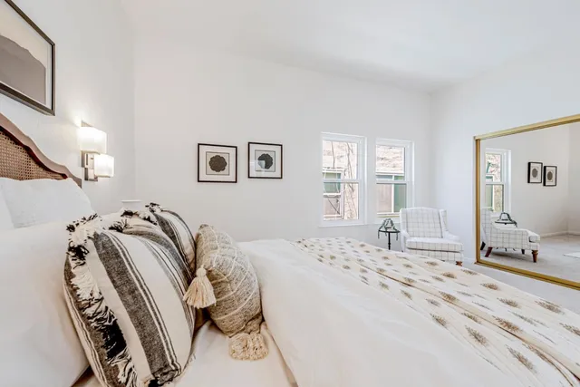 a bathroom with a toilet sink double vanity and mirror