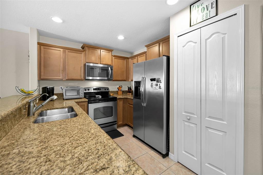 9736 Trumpet Vine Loop Trinity, FL 34655 - Photo 12 of 35 a kitchen with granite countertop a refrigerator and a sink