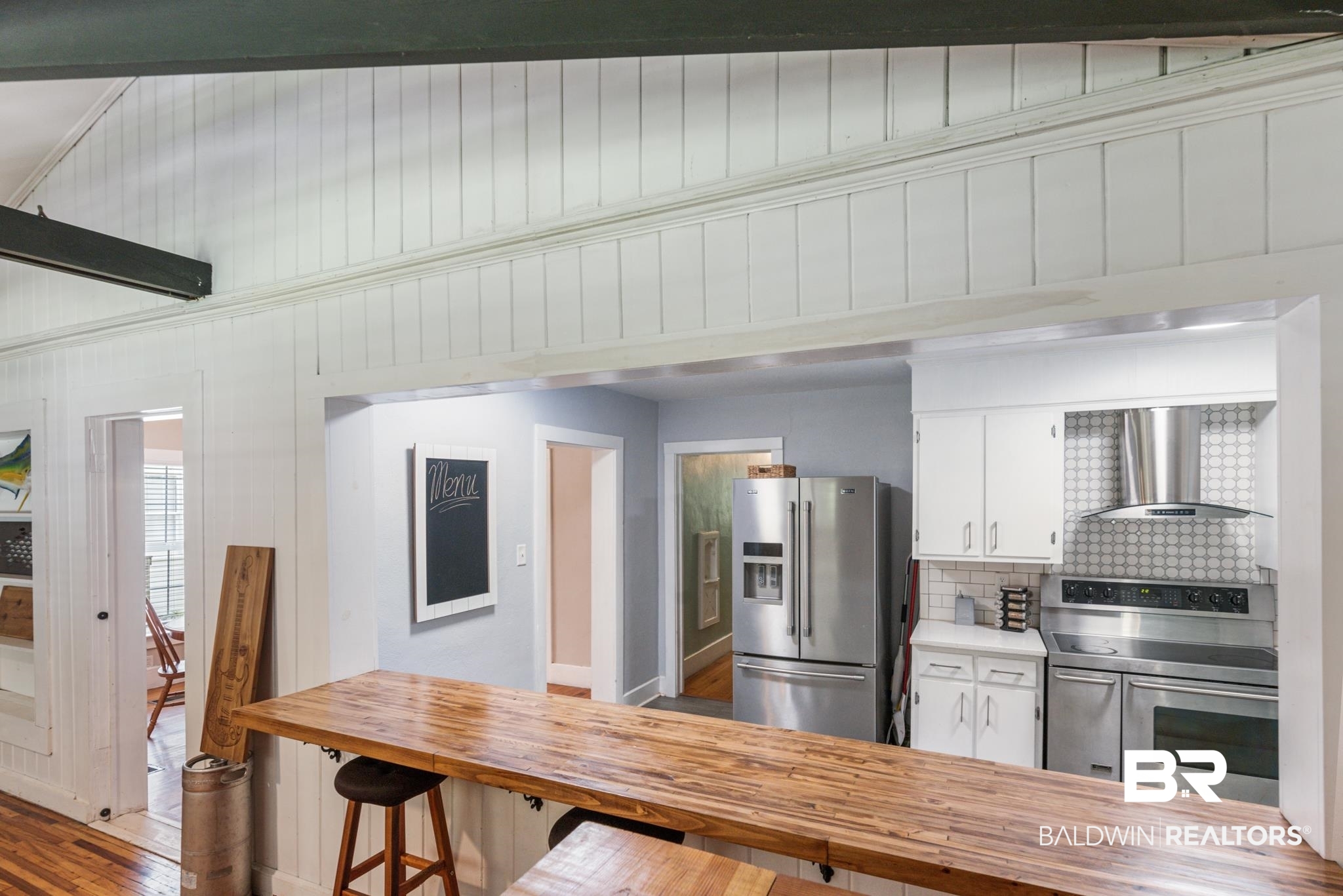 114 Crenshaw Street Mobile, AL 36606 - Photo 20 of 49 Kitchen with white cabinetry, wall chimney range hood, decorative backsplash, hardwood / wood-style floors, and appliances with stainless steel finishes