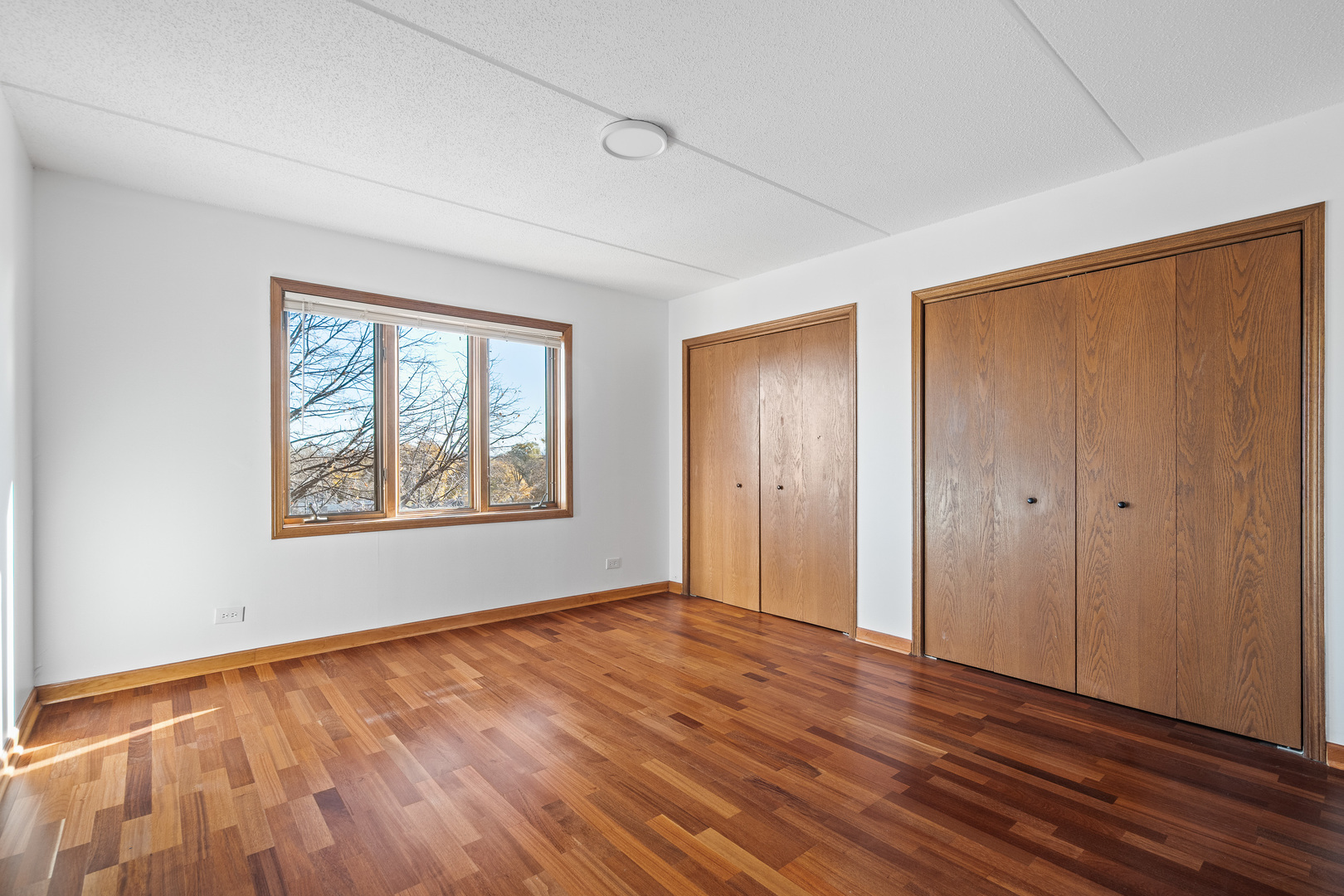 6400 West Berteau Avenue, Unit 405 Chicago, IL 60634 - Photo 13 of 22 a view of an empty room with window and wooden floor