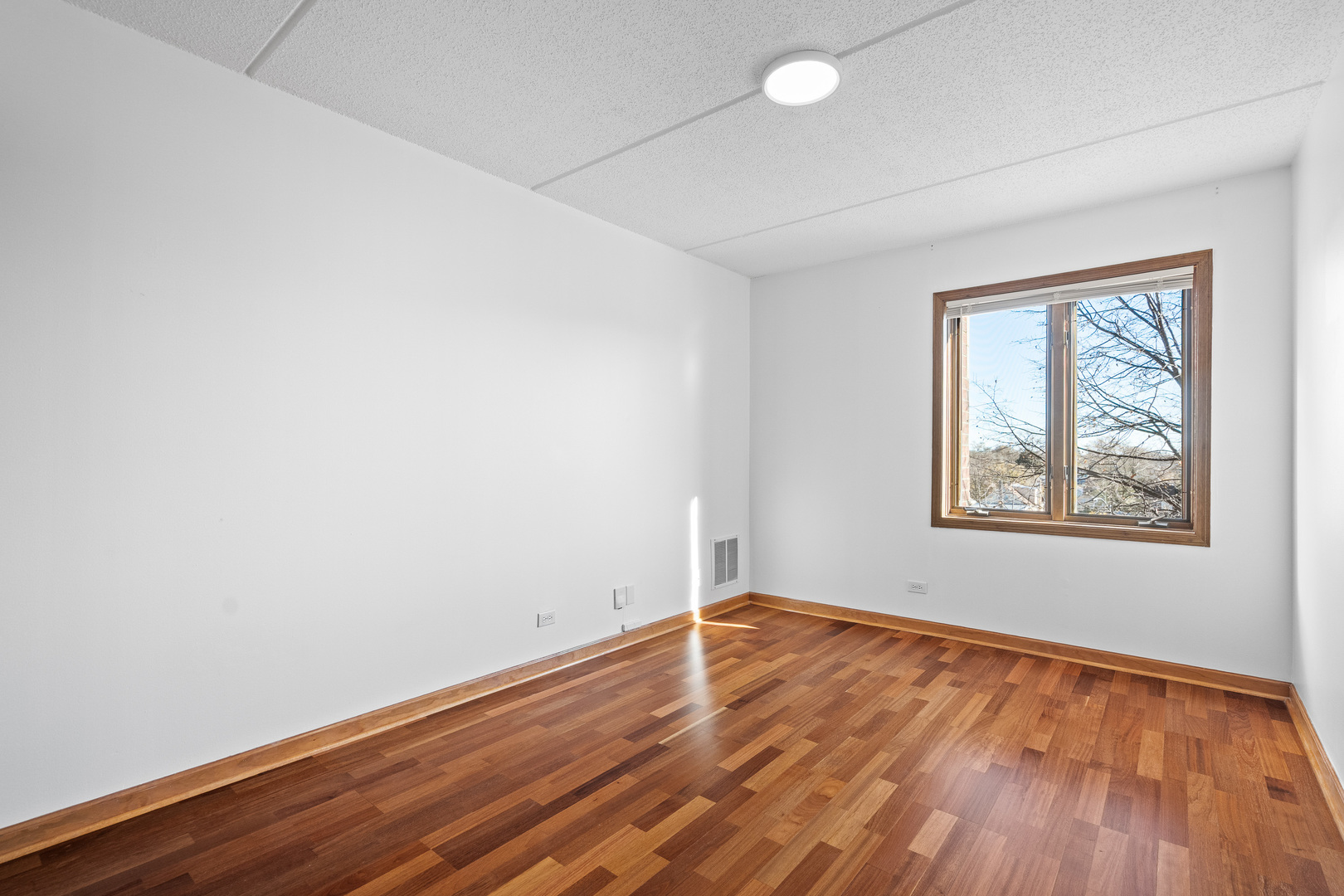 6400 West Berteau Avenue, Unit 405 Chicago, IL 60634 - Photo 14 of 22 an empty room with wooden floor and windows